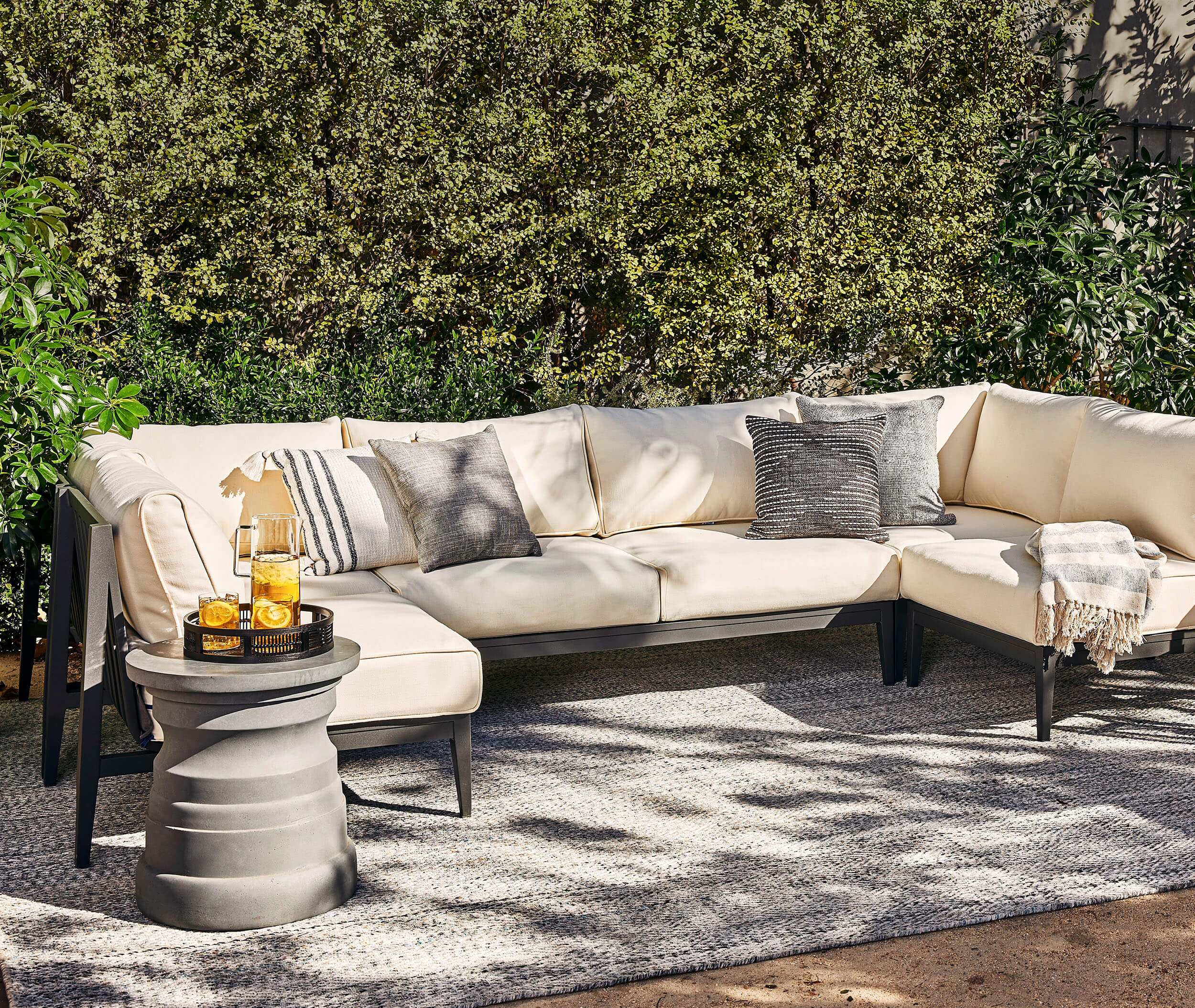 Outdoor sectional sofa arranged on an outdoor rug

