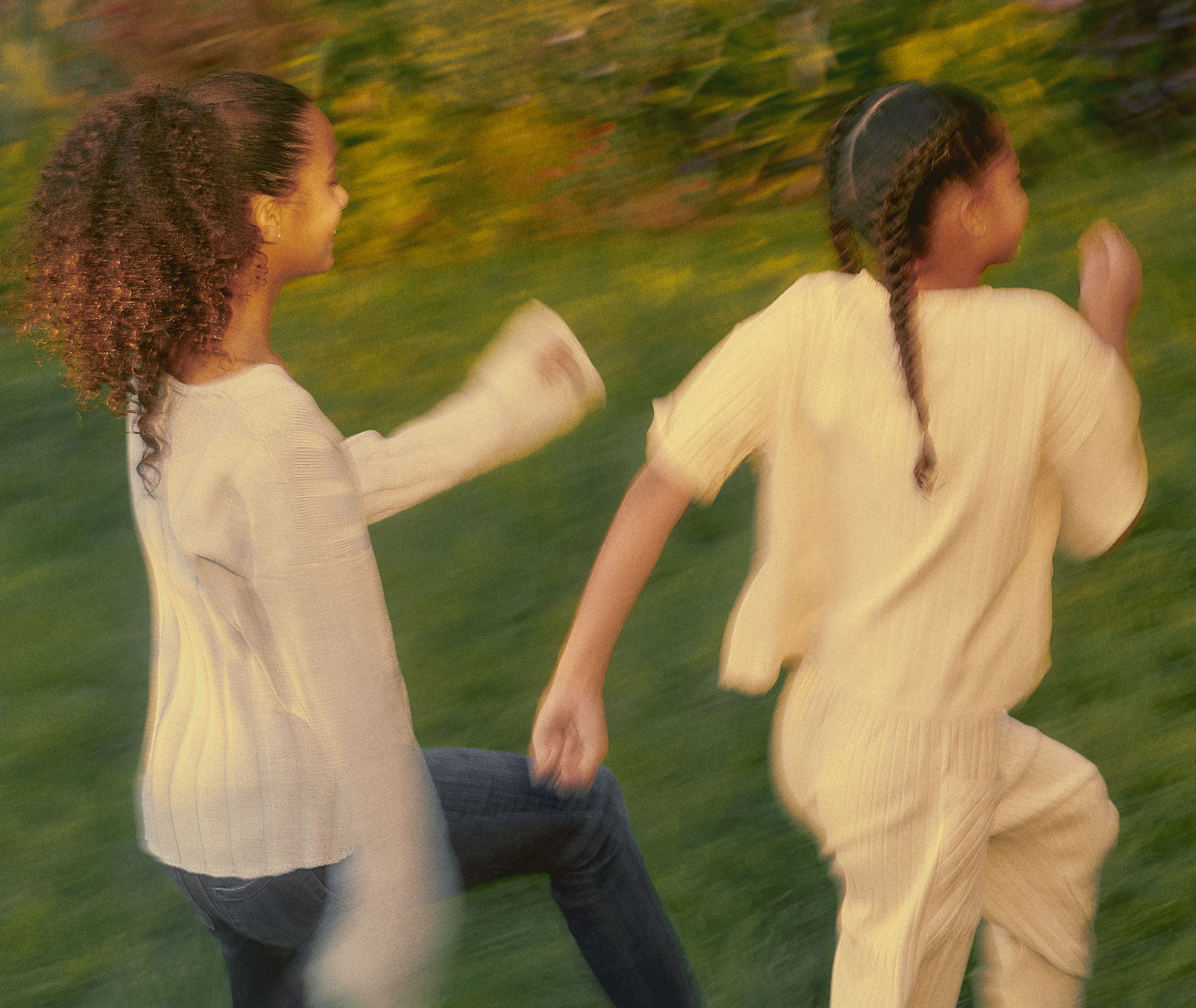 Children running together outdoors, reflecting Outer’s values of connection, care, and a future shaped by nature