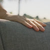 Video showing OuterCloud cushion technology on Outer outdoor seating, with close-up hand pressure demonstrating cloud-like softness, body-contouring support, and plush comfort from a three-layer memory foam design.