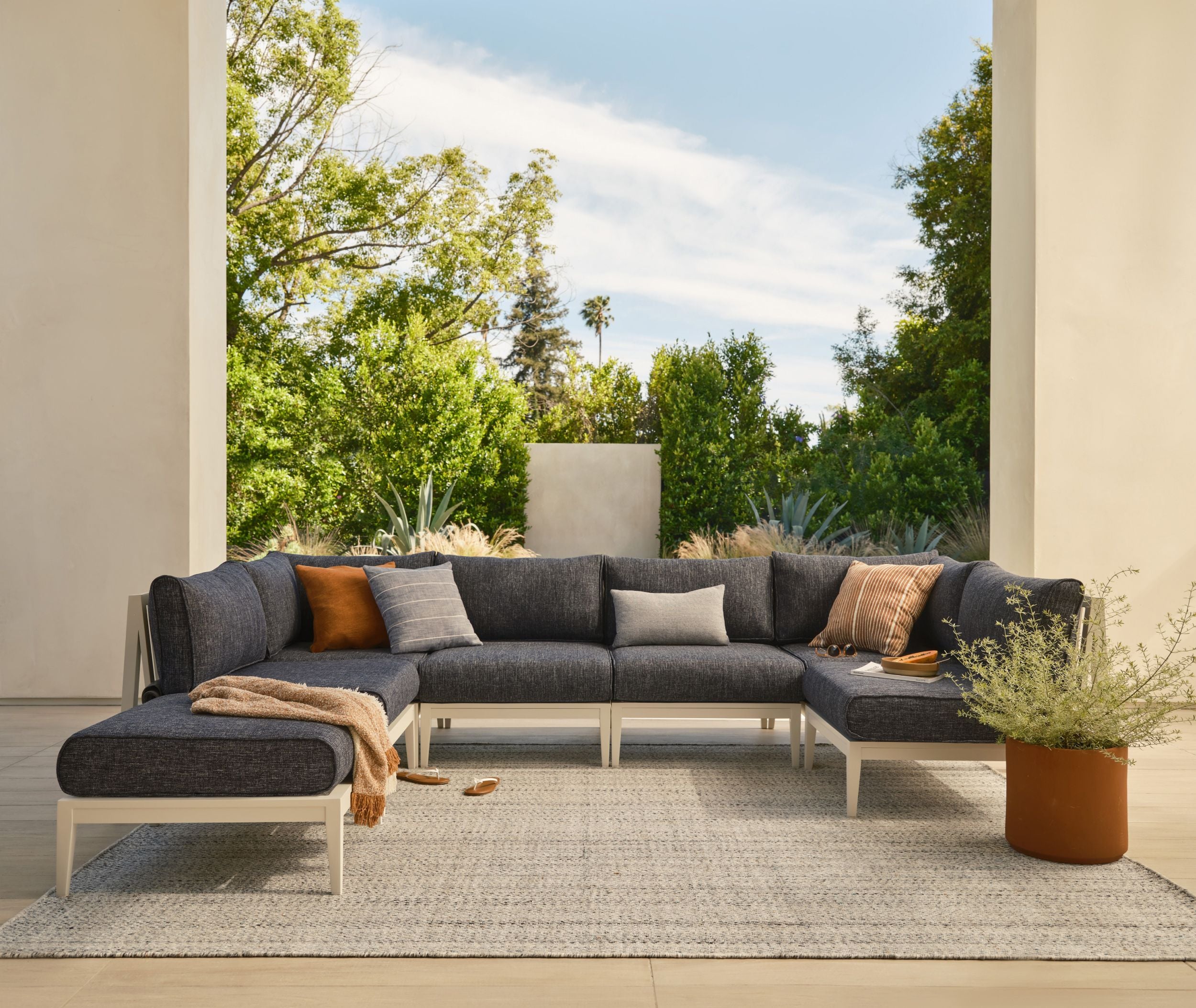 Modular outdoor sectional sofa with cushions arranged in a covered patio
