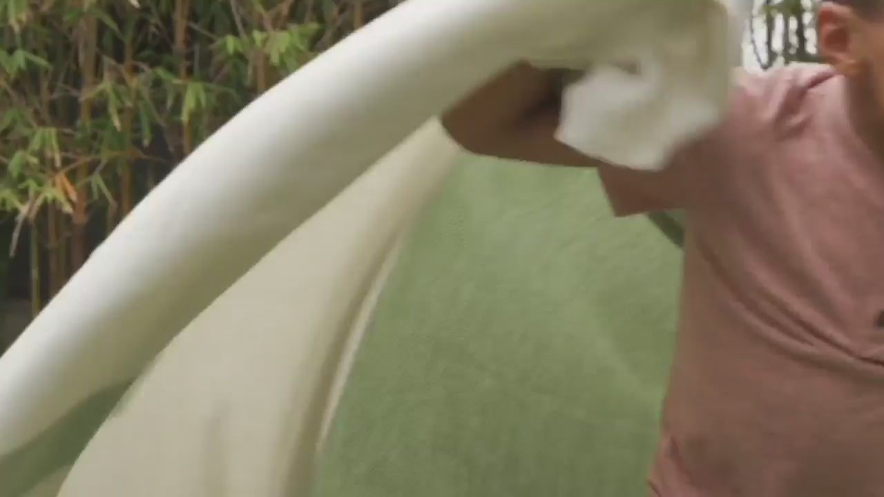 Bug Shield outdoor blanket draped over a child sitting on a sofa, showing full-body coverage and fabric texture
