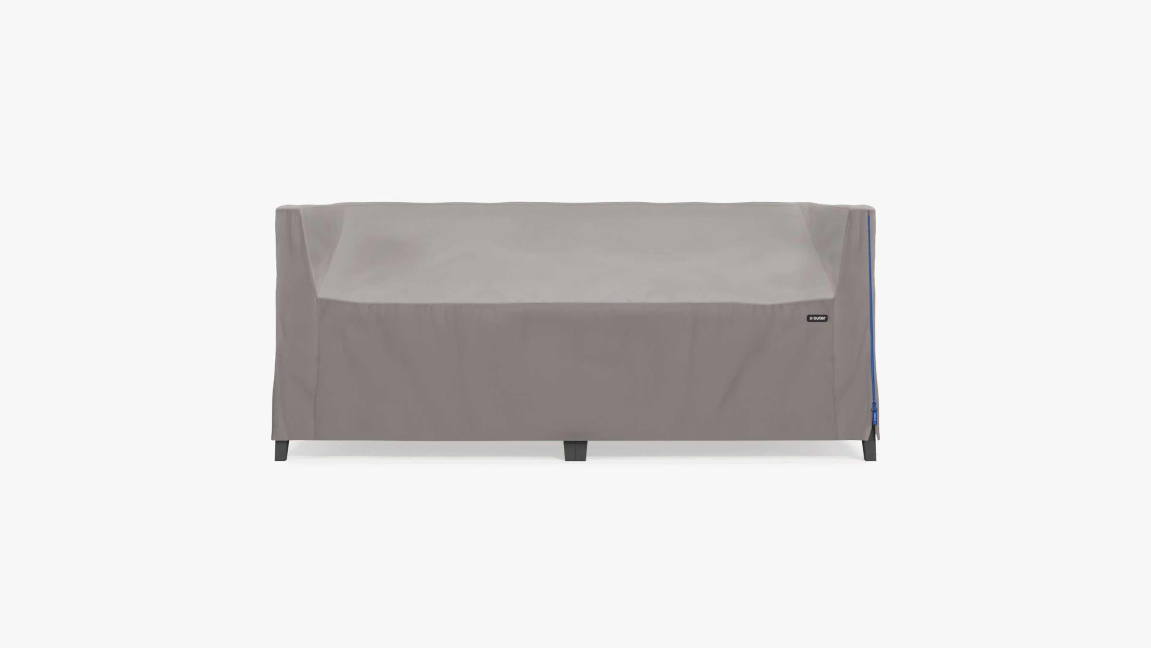 Protective outdoor furniture cover fitted over an aluminum loveseat