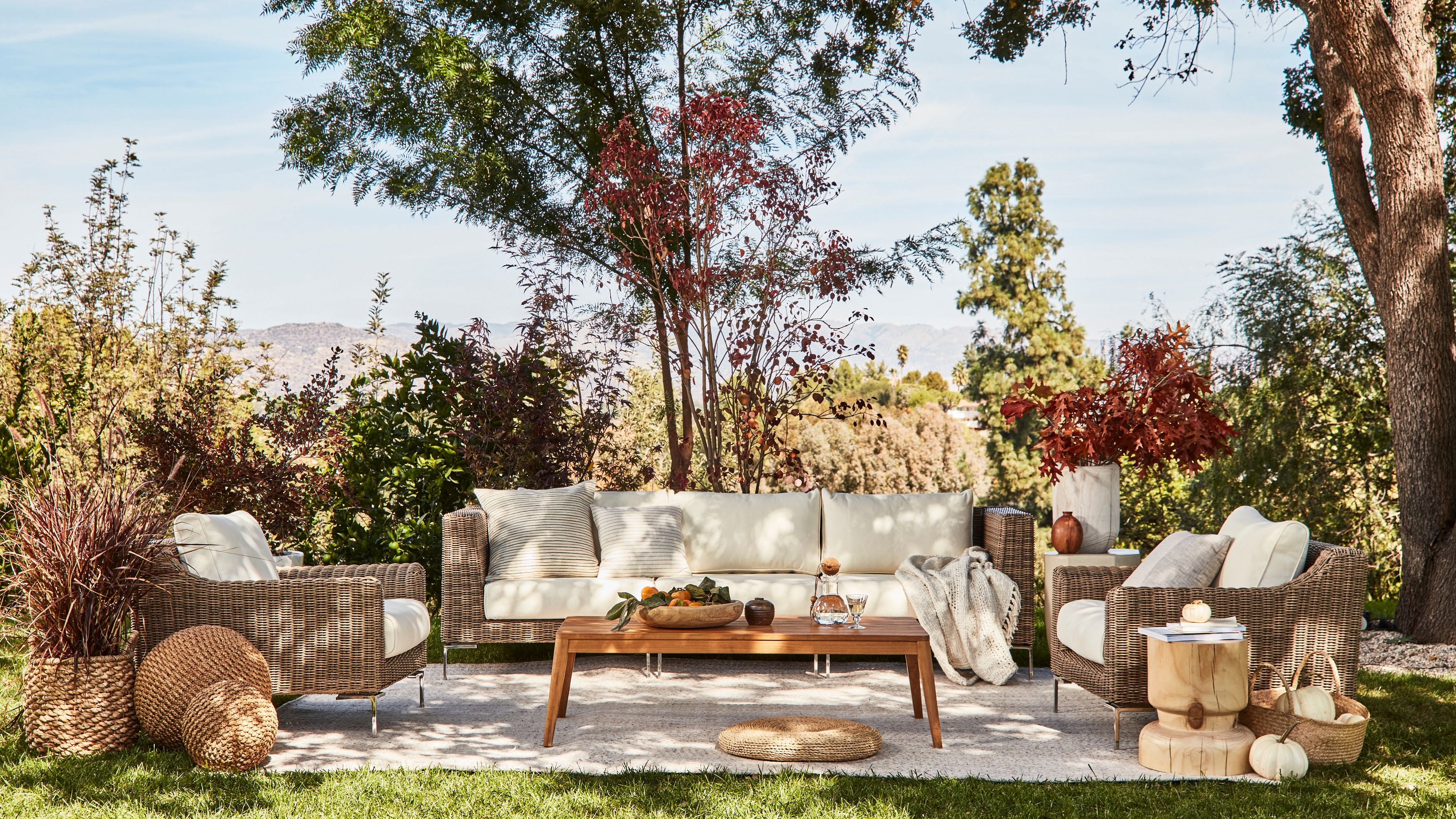 Comfortable and durable all-weather-wicker outdoor sofa in palisades cream with teak coffee table.